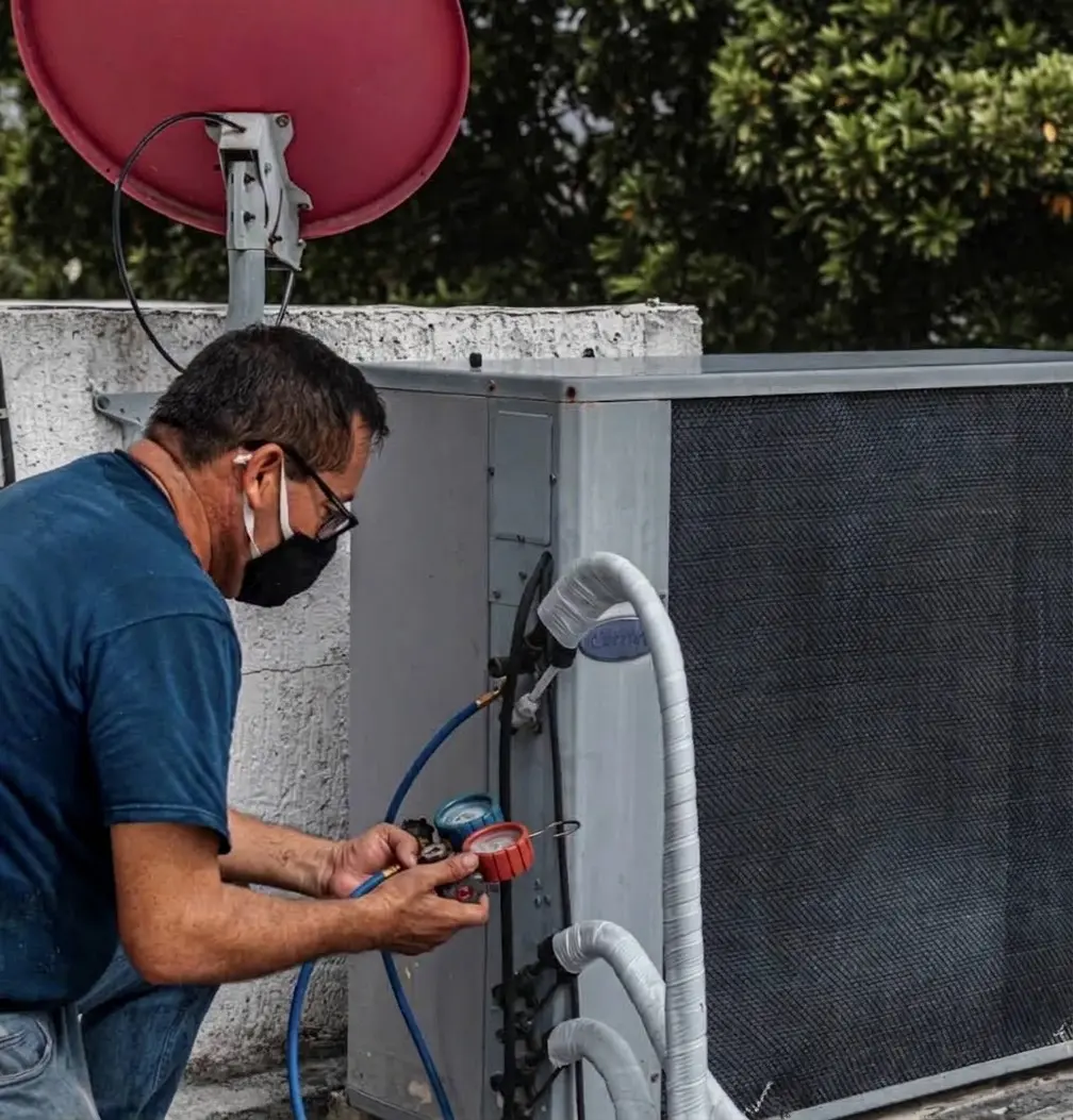 Técnico realizando mantenimiento a equipo de aire acondicionado